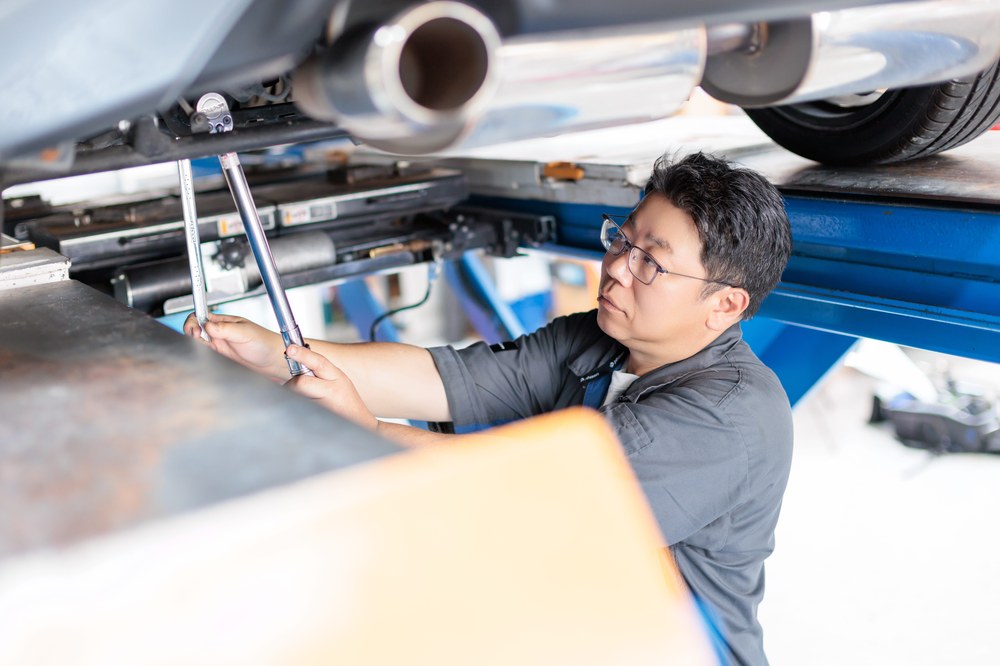 車の下で足回りを調整する診断士
